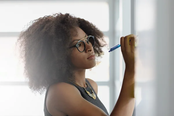 Retrato de una mujer de negocios sonriente con un afro en la oficina de cristal brillante — Foto de Stock