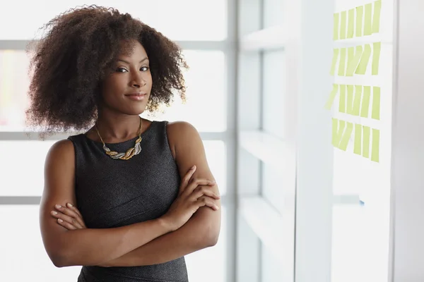 Retrato de una mujer de negocios sonriente con un afro en la oficina de cristal brillante — Foto de Stock