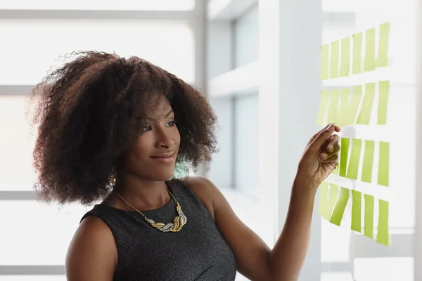 Porträt einer lächelnden Geschäftsfrau mit einem Afro im hellen Glasbüro — Stockfoto