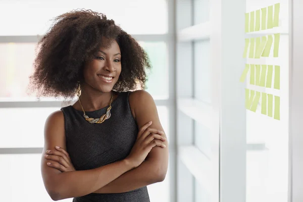 Porträt einer lächelnden Geschäftsfrau mit einem Afro im hellen Glasbüro — Stockfoto
