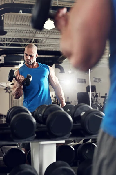 Bodybuilder träna med bumbbells vikter på gymmet — Stockfoto