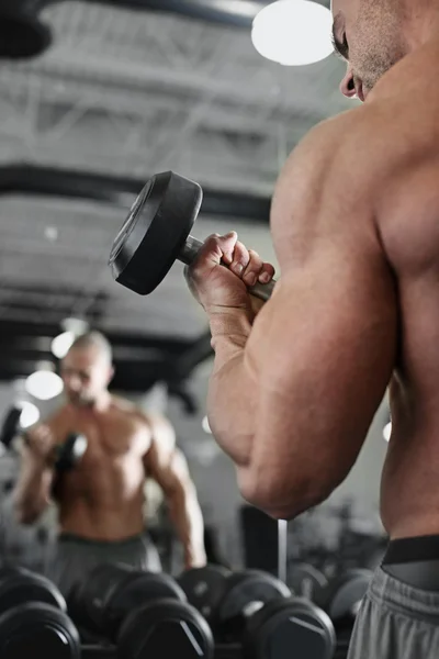 Bodybuilder travailler avec haltères poids à la salle de gym — Photo