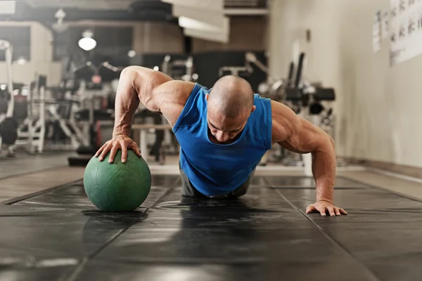 Kroppsbyggare tränar och gör push upsat gymmet medan — Stockfoto