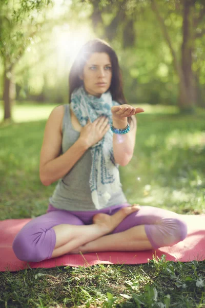 Lugn och fredlig kvinna öva medveten medvetenhet genom att meditera i naturen med solen flare. — Stockfoto