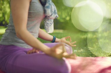 Sakin ve huzurlu kadın dikkatli bilinci ile arka plan bokeh gün batımında doğada meditasyon pratik.