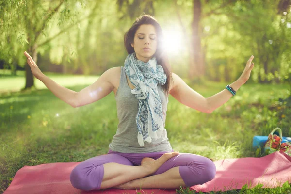 Lugn och fredlig kvinna öva medveten medvetenhet genom att meditera i naturen med solen flare. — Stockfoto