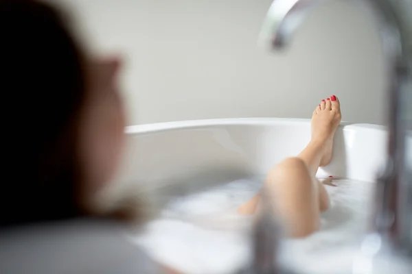 Hübsche reife Frau schaut weg in einer Badewanne — Stockfoto