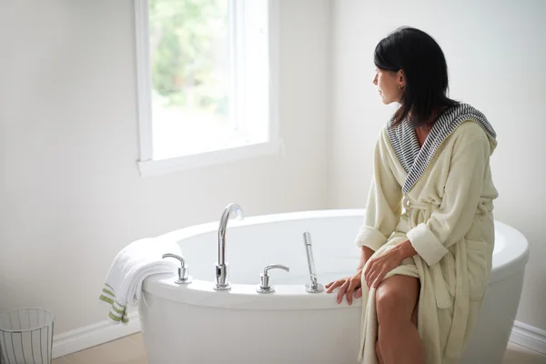 Ruhige reife Frau sitzt an einer Badewanne — Stockfoto