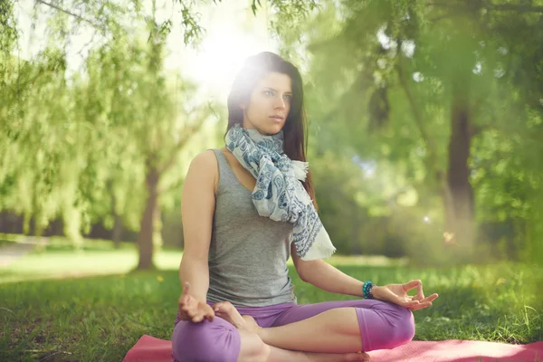 Femme sereine et paisible pratiquant la conscience consciente en méditant dans la nature avec une éruption de soleil . — Photo