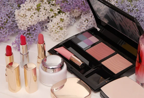 Cosmetics and lilac blossom, lipstick, eyeshadow — Stock Photo, Image