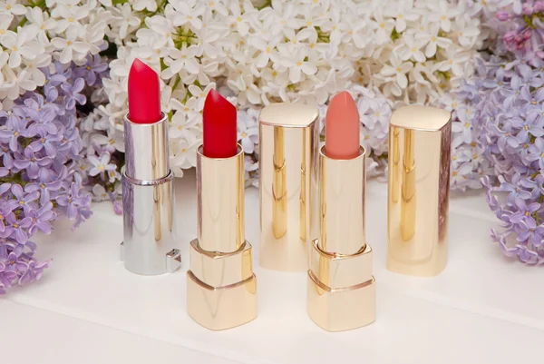 Lipsticks and blossoming lilac — Stock Photo, Image