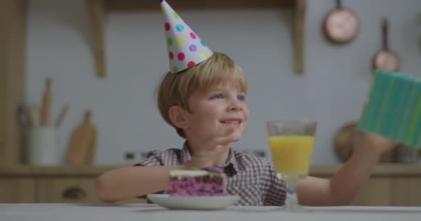 Criança feliz aniversário recebendo presente e desembrulhando presente de aniversário. O rapaz saiu para abrir o presente de aniversário. Celebração de aniversário sozinho. — Vídeo de Stock