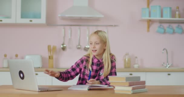 学校の子供は自宅でラップトップでオンラインで勉強しながらオンライン教師を迎えます。ブロンド10歳の女の子学習とともに距離学校オンライン. — ストック動画