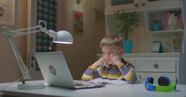 Enfant d'âge préscolaire étudiant en ligne à la maison. Éducation en ligne et enseignement à distance pour les enfants. Jeune garçon écoute la tâche de l'enseignant à partir d'un ordinateur portable et met sa main vers le haut. — Video