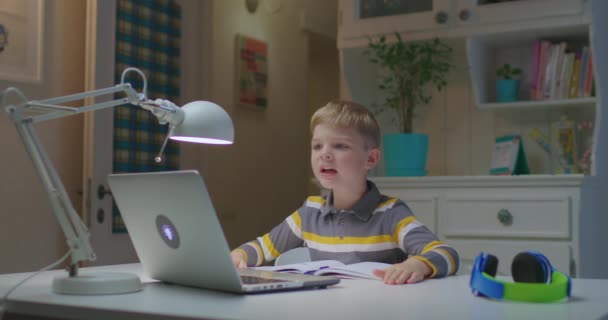 Bambino in età prescolare che canta al computer portatile online a casa. Educazione online e apprendimento a distanza per bambini. Giovane ragazzo che legge poesia. — Video Stock