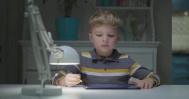 İlköğretim çağındaki çocuklar tablet bilgisayarla öğreniyor. Tablet bilgisayar kullanan genç bir öğrenci. Çevrimiçi eğitim ve çocuklar için uzaktan öğrenme. 