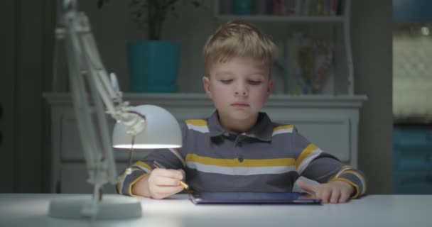 Елементарний вік дітей, які навчаються за допомогою планшетного комп'ютера. Молодий школяр використовує планшетний комп'ютер. Онлайн-освіта та дистанційне навчання для дітей . — стокове відео
