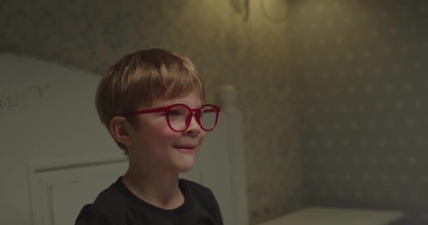 Aranyos kisfiú szemüveg énekel és mosolyog. Boldog gyerek otthon.. — Stock videók