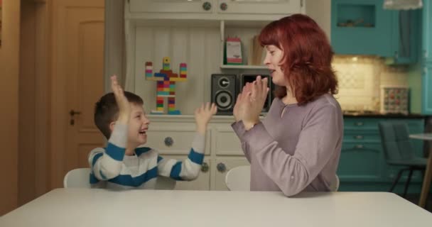 Autisme therapeut speelt hand en vinger spel met kind met autisme. School jongen met autisme studeren met moeder thuis. Coördinatie autistisch leren van kinderen. — Stockvideo