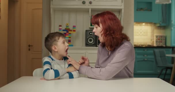 音声療法士は音声を発音する自閉症の子供を教えています。家庭で母親と自閉症の学習を持つ学校の少年。自閉症スペクトラム障害教育. — ストック動画