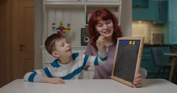 Psicólogo autista enseñando a un niño con autismo a leer cartas. Niño de escuela con autismo aprendiendo con la madre en casa. Educación sobre el trastorno del espectro autista. — Vídeos de Stock