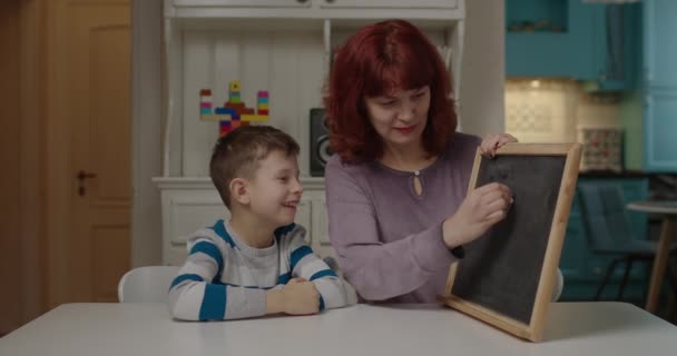 Terapeuta autista enseñando a un niño con autismo matemático a bordo. Escolar con autismo aprendiendo con la madre en casa. — Vídeos de Stock