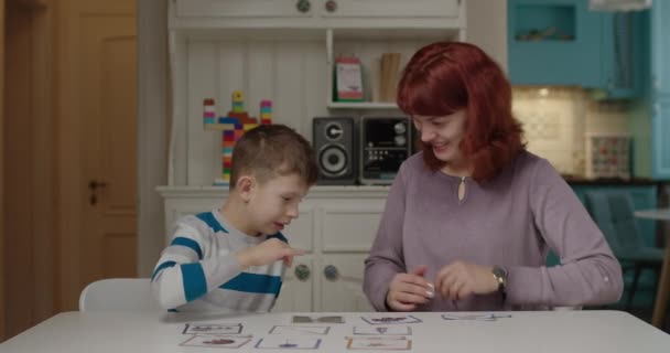 Terapeuta del autismo que trabaja con niños con autismo para practicar habilidades en la lectura. Niño de escuela con autismo aprendiendo con la madre en casa. Niño autista que empareja palabras con imágenes. — Vídeos de Stock