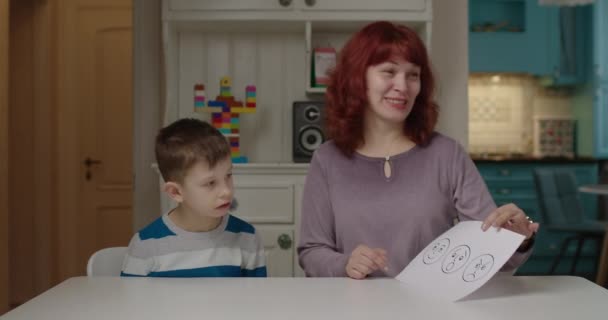 Psicólogo autista ensinando criança com emoções de autismo. Menino da escola com autismo aprendendo com a mãe em casa. Aprendendo sentimentos felizes, surpresa e chateados por cartão. — Vídeo de Stock