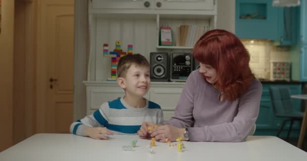 Аутист-терапевт навчає дитину аутизму. Шкільний хлопчик з аутизмом вивчає тварин з матір'ю. Освіта аутистичного спектру розладів вдома . — стокове відео