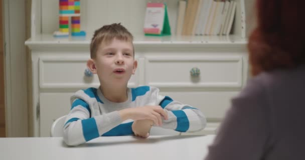 Kind met autisme lacht tijdens de les bij autistische therapeut. Kinderen psycholoog werkt met jongen met autisme spectrum stoornis. — Stockvideo