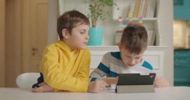 Eğitim başvurusu için bir tablet bilgisayar kullanan iki otistik çocuk. Otizm spektrum bozukluğu eğitimi çevrimiçi.