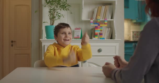 Niño con autismo jugando juego de dedos con el terapeuta. Niño de escuela con autismo estudiando con la madre en casa. Niño autista aprende a centrar la atención y la coordinación. — Vídeo de stock