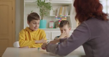 İki otistik çocuk terapistle hayvan öğreniyor. Otizmli çocuklar evde eğitim görüyor. Otizm bozukluğu olan iki öğrenci..