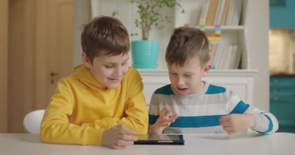 Два хлопчики з аутизмом використовують один планшетний комп'ютер для навчання. Освіта аутистичного спектру розладів онлайн . — стокове відео