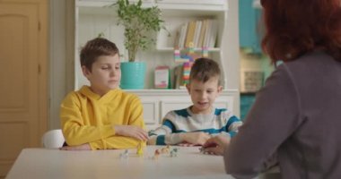 Otizm terapisti otizmli çocuklara öğretiyor. Otizmli iki okul çocuğu özel öğretmenleriyle hayvan öğreniyor. Evde otizm spektrum bozukluğu eğitimi.