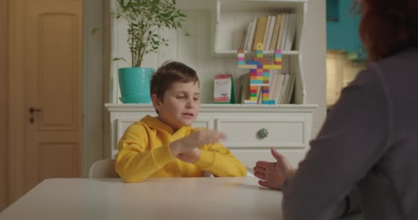 Otizmli çocuk psikologla oynuyor. Otistik çocuk dikkat ve koordinasyonu öğreniyor. Otizmli okul çocuğu evde annesiyle ders çalışıyor.. — Stok video