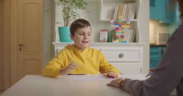 Autisme therapeut werkt met kind met autisme. Jongen schrijven en lezen. Thuisonderwijs met docent. — Stockvideo