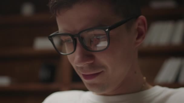 El primer plano del estudiante en las gafas de ojo con el reflejo del hombre que escribe en el portátil. Hombre freelancer escribiendo en el ordenador portátil, navegar por Internet. Millennial estudiando en casa. — Vídeos de Stock