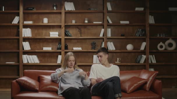 Millennial couple talking sitting together on the couch. Boyfriend and girlfriend at home. Family evening entertainment. — Stock Video