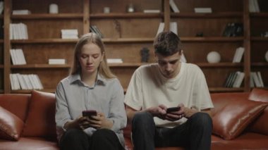 Komik bir çift cep telefonu kullanıyor ve 5G radyasyon korkusu yüzünden folyo başlık takıyor. Elektromanyetik radyasyon korumanın garip bir yolu. Milenyum çifti folyo kapağıyla eğleniyor..