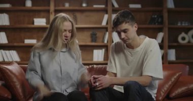 Genç kadın kocasına şikayet ediyor. Milenyum çifti kanepede tartışıyor. Aile ilişkileri sorunları.