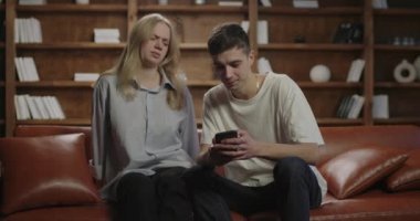 Koca, karısının cep telefonuyla fotoğraflarını çekiyor. Sosyal ağlar için resim yapıyorum. Adam kadının cep telefonuyla fotoğraf çekmesine yardım ediyor. Sosyal medya içeriği üretim süreci. 