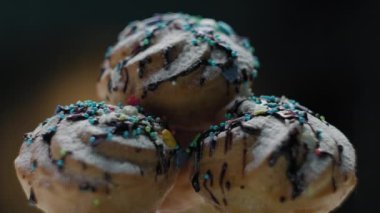 Kremalı profiterol ve üstüne renkli şeker dökülmüş çikolata. Tatlı renkli kaplamalı hamur işlerini kapat..