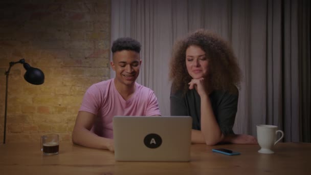 Millennial gemengd ras koppel praten met laptop zitten aan tafel thuis. Afro-Amerikaanse man en zijn vrouw praten met ouders via videogesprek. — Stockvideo