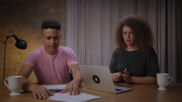 Millennial multiethnic pár podvádění při on-line pohovoru na novou práci. Africký americký přítel pomáhá přítelkyně odpovědět na otázky on-line interview. — Stock video