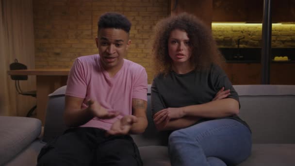 Afro-Amerikaanse vriend sorteren ding uit met vriendin zitten op de bank en praten op de camera met relatie specialist online. — Stockvideo