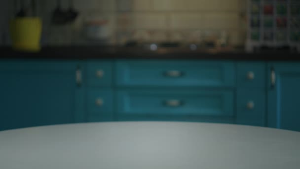 Mão feminina colocando flores amarelas em panela na mesa na cozinha azul. Casa flores em vaso no interior. — Vídeo de Stock
