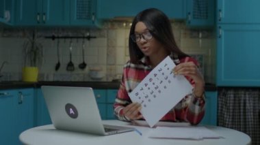 Genç, 20 'li yaşlarda, gözlüklü Afrikalı Amerikalı bir öğretmen basit matematiksel denklemlerle evdeki laptopa bakıyor. Evde internet öğretmenliği yapıyorum.. 