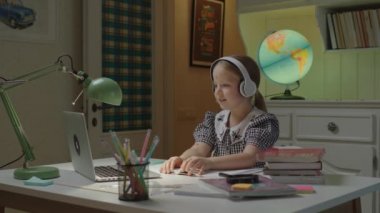 Güzel liseli kızın internet müzik dersi var. Çocuk dizüstü bilgisayara bakarak şarkı söylüyor. Çocuklar için uzaktan öğrenim ve evde eğitim.