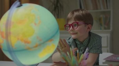 Anaokulu çocuğu evde Dünya 'yı keşfediyor. Gözlük takan öğrenci evde coğrafya öğreniyor. Şimşek dönen küre.